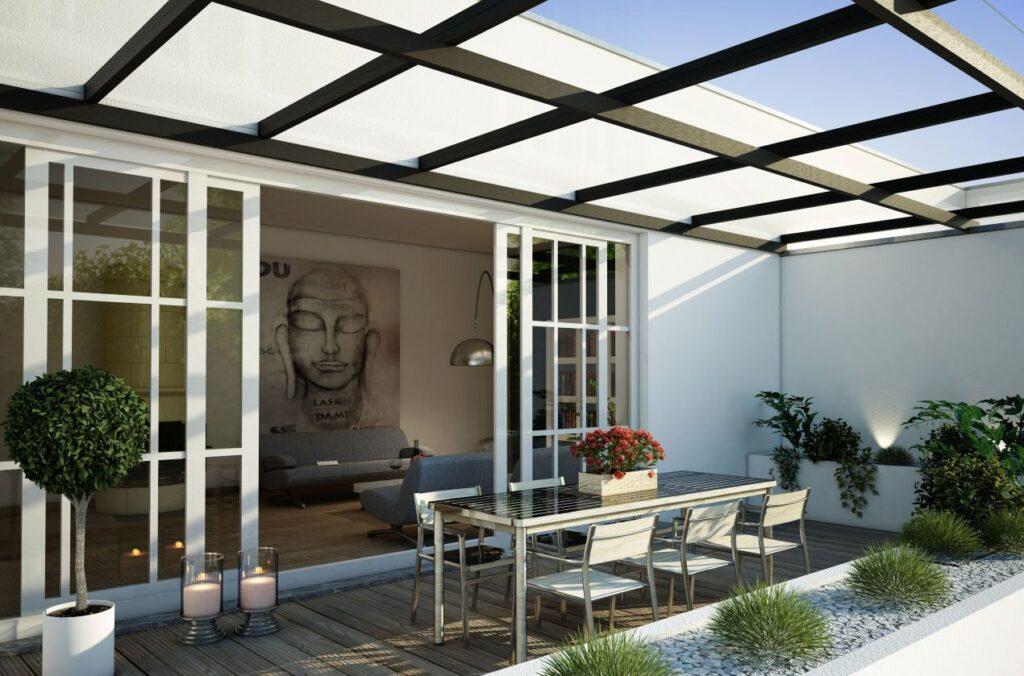 Terrassenueberdachung mit Glasdach und Lounge-Ecke im modernen Stadthaus – harmonischer Uebergang von Innen- zu Aussenbereich